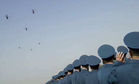 Chinese People's Liberation Army Air Force officers watch helicopters during a celebration.