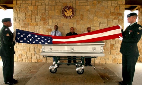U.S. Army honor guards from Fort Hood, Sgt. Kristopher Tate, left, and Spc. Patrick Debord, right, fold a flag in front of the casket carrying the body of homeless veteran Harold Dean Harris.