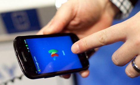 A person tries a smartphone loaded with Google Wallet A person tries a smartphone loaded with Google Wallet