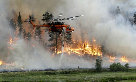 A helicopter drops water as it assists in firefighting efforts at the Taylor Creek fire 25 miles southeast of Ashland, Montana. A helicopter drops water as it assists in firefighting efforts at the Taylor Creek fire 25 miles southeast of Ashland, Montana.