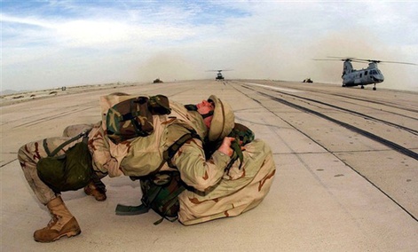 Deployed from USS Bataan and arriving in Afghanistan with a heavy backpack, a Marine with the 26th Marine Expeditionary Unit (Special Operations Capable), dons his backpack by laying his back on it. Deployed from USS Bataan and arriving in Afghanistan with a heavy backpack, a Marine with the 26th Marine Expeditionary Unit (Special Operations Capable), dons his backpack by laying his back on it.