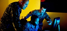 Three military cyber professionals conduct an exercise during Cyber Flag 13-1, Nov. 8, 2012, at Nellis Air Force Base, Nev. 