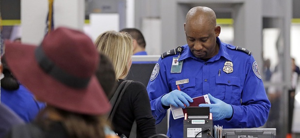 A Transportation Security Administration agent checks traveling documents of a passenger at Miami International Airport. A Transportation Security Administration agent checks traveling documents of a passenger at Miami International Airport.
