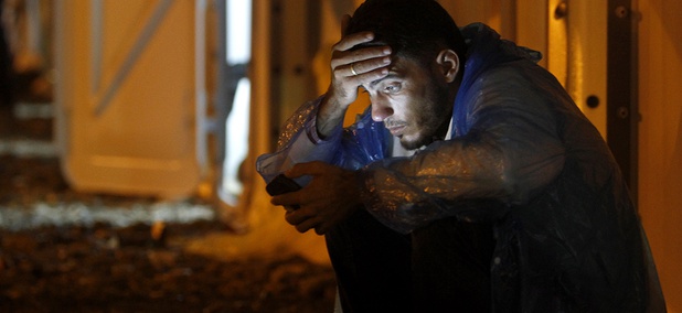 A man looks at his mobile phone while waiting for a train heading toward Serbia, at the transit camp for refugees near the southern Macedonian town of Gevgelija. A man looks at his mobile phone while waiting for a train heading toward Serbia, at the transit camp for refugees near the southern Macedonian town of Gevgelija.