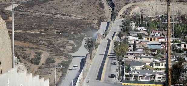 A Border Patrol vehicle drives by the border fence in Tecate, Calif., left, along the metal barrier that lines the border Wednesday, Nov. 9, 2016, seen from Tecate, Mexico. A Border Patrol vehicle drives by the border fence in Tecate, Calif., left, along the metal barrier that lines the border Wednesday, Nov. 9, 2016, seen from Tecate, Mexico.