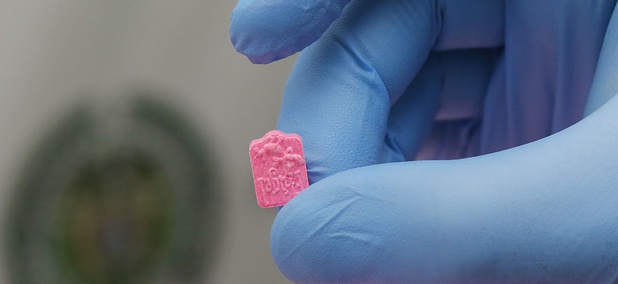 A police officer holds a single MDMA tablet, also known as ecstasy. A police officer holds a single MDMA tablet, also known as ecstasy.