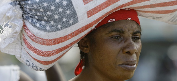 a woman carries a bag containing rice donated by the United States Agency for International Development. a woman carries a bag containing rice donated by the United States Agency for International Development.