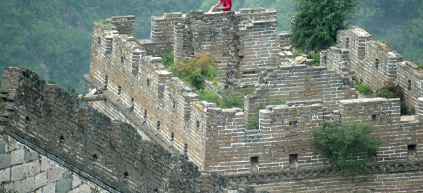 A man rests on a guard tower on the Great Wall of China.