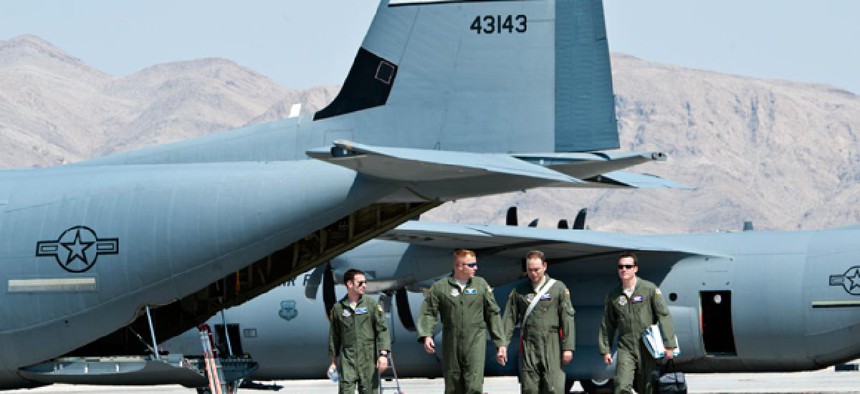 U.S. Air Force Weapons School students and evaluators walk on the flight line at Nellis Air Force Base, Nev.