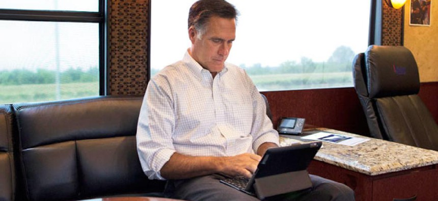 Mitt Romney works on an iPad while campaigning.