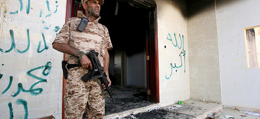 A Libyan military guard stands in front of one of the U.S. Consulate's burnt out buildings.
