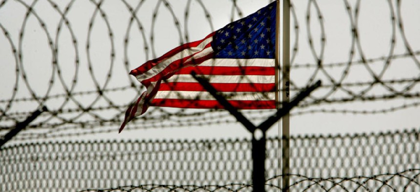 An American flag waves behind the razor-wire fences within the Camp Delta military-run prison at Guantanamo Bay.