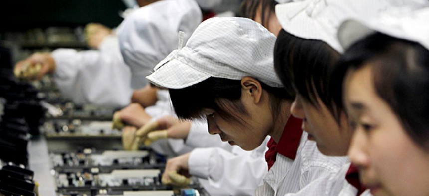 Staff members work on the production line making Apple products at the Foxconn complex in Shenzhen, China