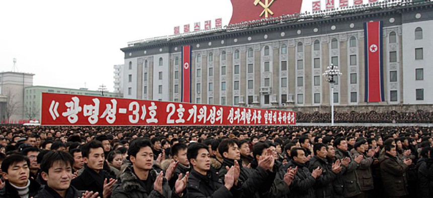 North Koreans applaud near a slogan which reads “(we) fervently celebrate the successful launch of the second version of the Kwangmyongsong-3 satellite 2nd version" during a mass rally in Pyongyang.