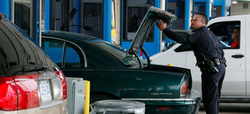 U.S. Customs and Border Patrol officer Jefferey Hill checks the trunk of a motorist's vehicle entering the United States at the border crossing in Buffalo, N.Y.