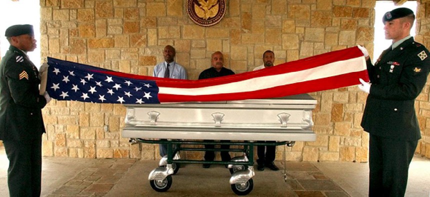 U.S. Army honor guards from Fort Hood, Sgt. Kristopher Tate, left, and Spc. Patrick Debord, right, fold a flag in front of the casket carrying the body of homeless veteran Harold Dean Harris.