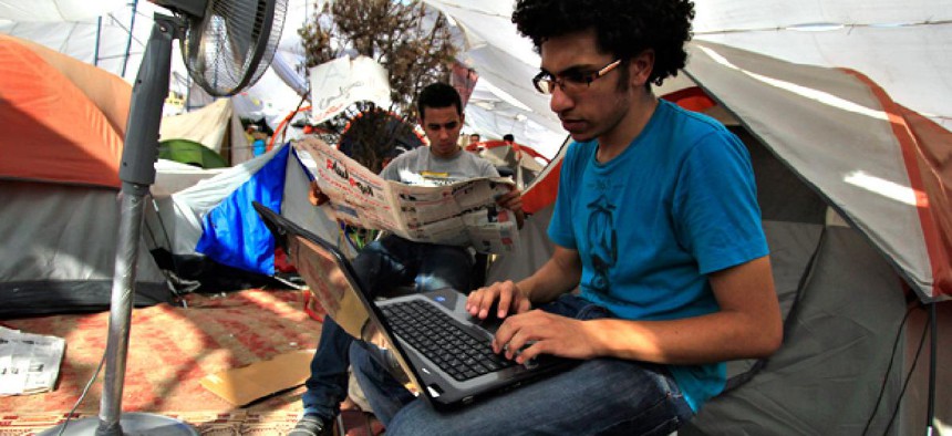 An Egyptian protester uses his laptop next to a cooling fan in Cairo's Tahrir Square in July 2011. 