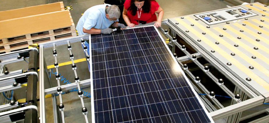 Stacey Rassas, right, a quality control manager at a Suntech Power Holdings Co., a Chinese-owned solar panel manufacturer, examines a solar panel.