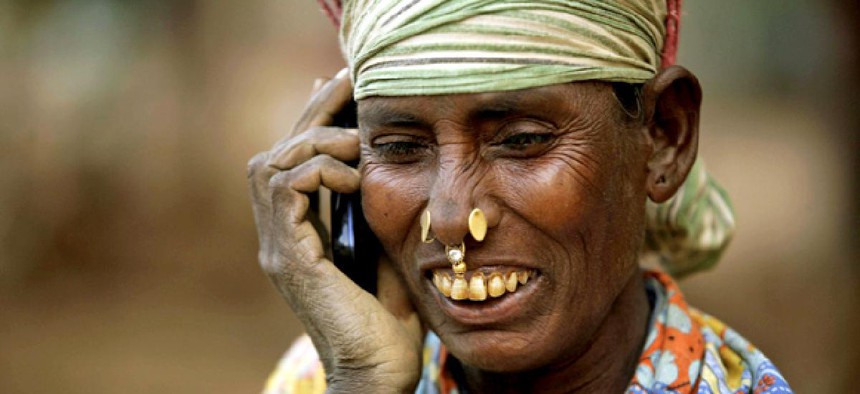 An Indian daily wage laborer talks on a mobile phone, at a construction site in Bhubaneshwar, India.