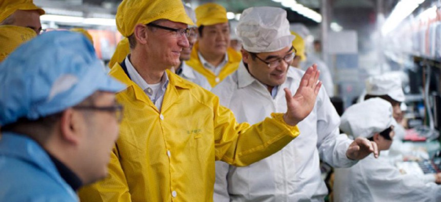 Apple CEO Tim Cook, center, visits the iPhone production line at the newly-built manufacturing facility Foxconn Zhengzhou Technology Park in China.