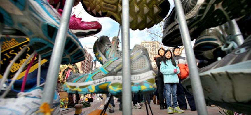 Visitors pause to view a growing collection of running shoes that are part of a makeshift memorial for the victims of the Boston Marathon bombing. 