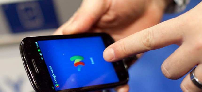 A person tries a smartphone loaded with Google Wallet 