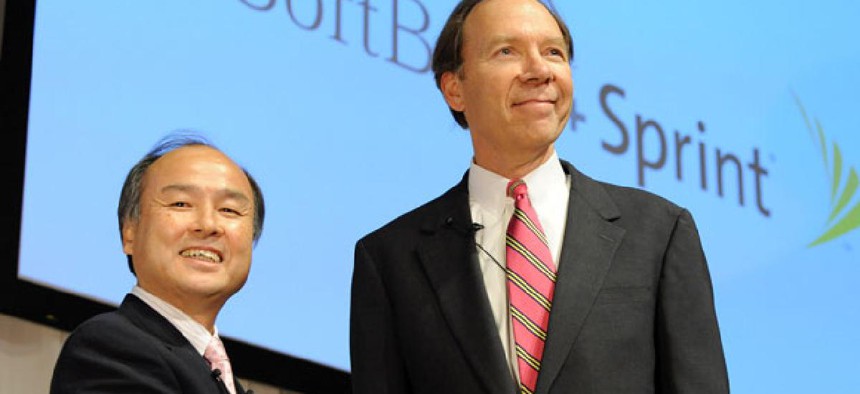 Son Masayoshi, left, president of Softbank Corp. shakes hands with Dan Hesse, CEO of Sprind Nextel Corp. 