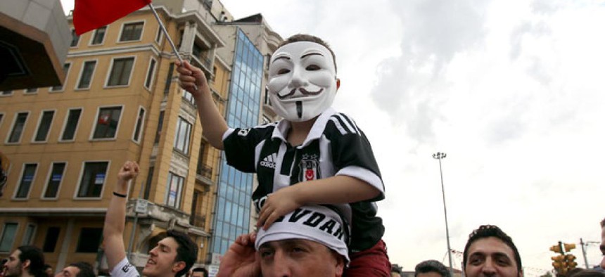 A boy on a man's shoulders wears a Guy Fawkes mask during the third day of anti-government protests in Istanbul. 