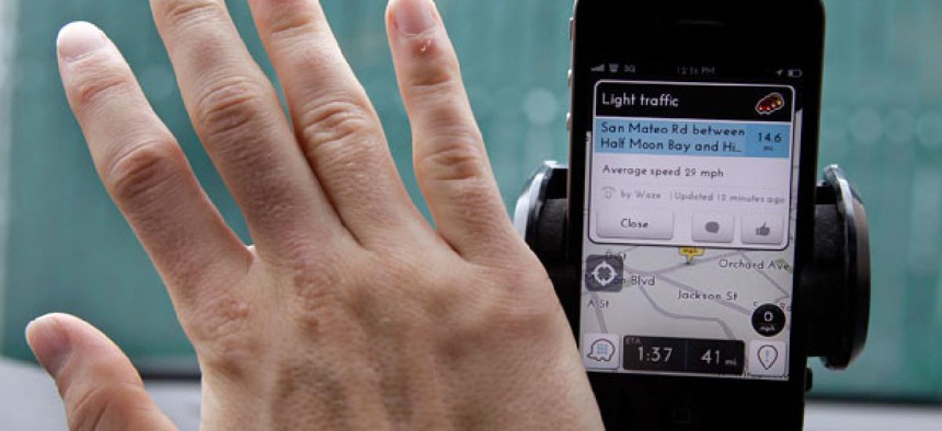 A user waves his hand over traffic and navigation app Waze. 