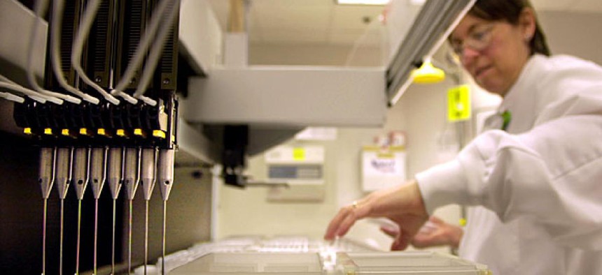A technician loads patient samples into a machine for testing at Myriad Genetics. 