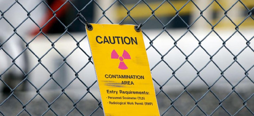 A sign warning of radioactive contamination dangles from a fence at the 'C' Tank Farm at the Hanford Nuclear Reservation.