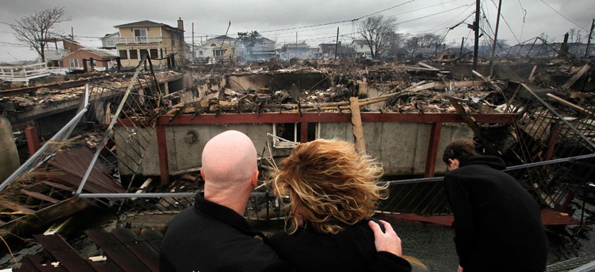 Robert Connolly and his wife Laura embrace has they survey the remains of a home in Breezy Point, New York, following Hurricane Sandy. 