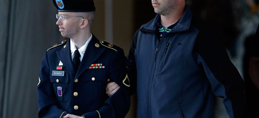 Army Pfc. Bradley Manning is escorted Monday afternoon.