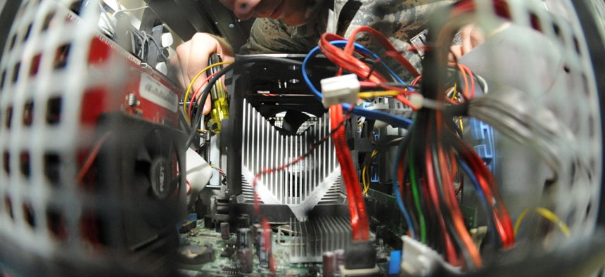 An airman removes a motherboard on a computer in June.