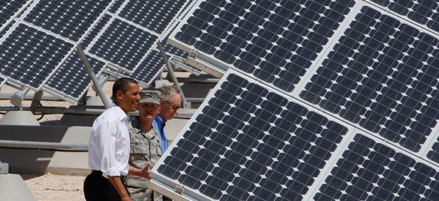 Barack Obama, Sen. Harry Reid, D-Nev.,  and Col. Howard Belote tour solar power panels at Nellis Air Force Base in 2009.
