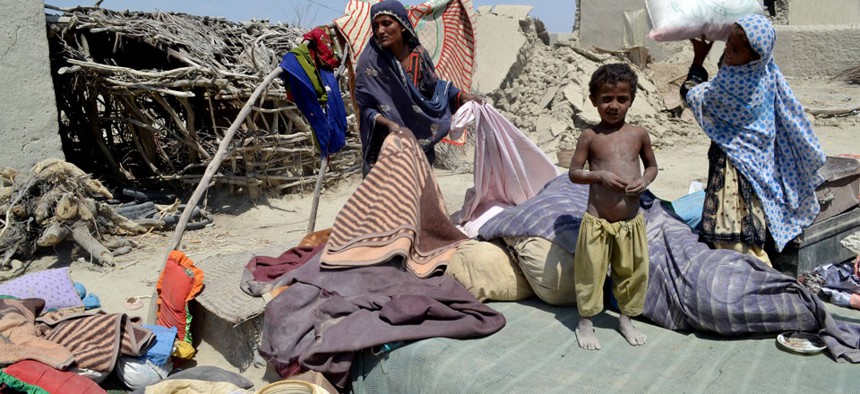 Pakistani villagers collect belongings from their destroyed homes following an earthquake in Labach, Pakistan.