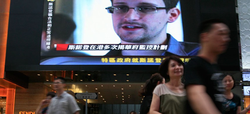 A TV screen shows a news report of Edward Snowden in Hong Kong in June.