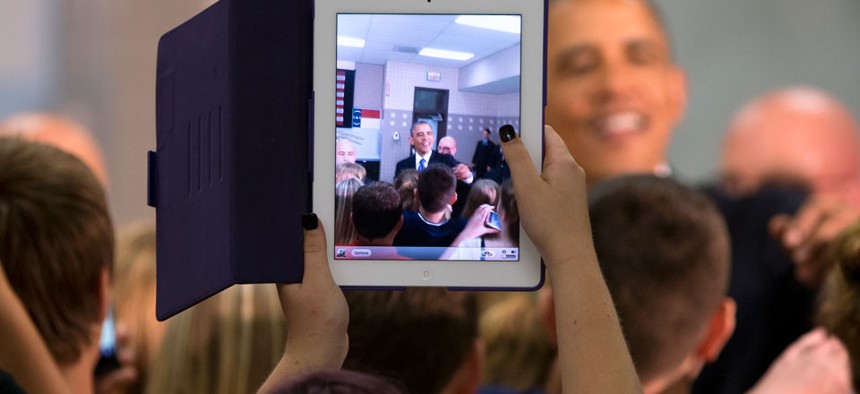 A student uses her iPad to snap a photo of the president in June. 