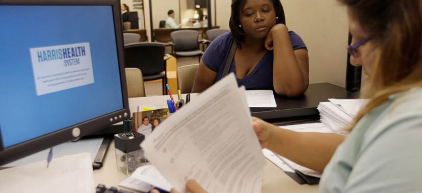 Lillian Ardon, right,  of Harris Health System, helps Vanessa Danielle Cotton, left, with her Affordable Care Act marketplace application on Oct. 1.
