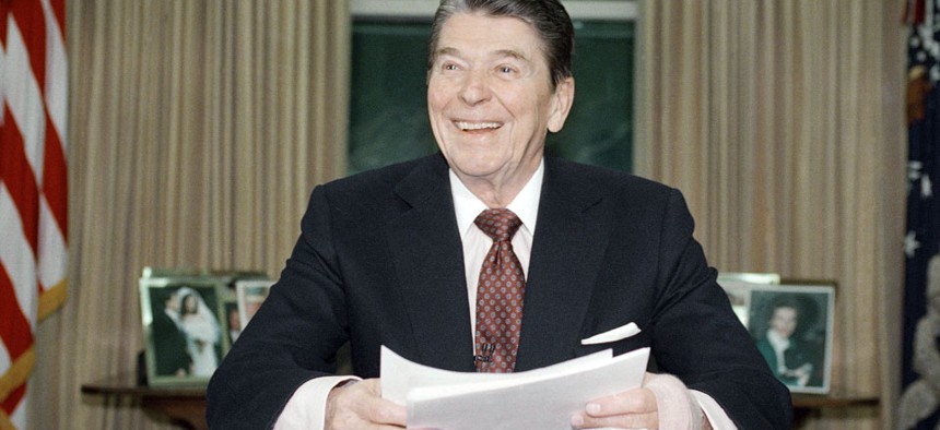 President Ronald Reagan poses for photographers in the Oval Office.