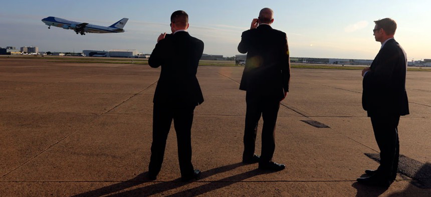 Secret Service agents watch as Air Force One departs in April.