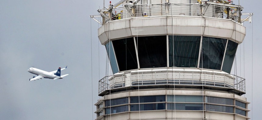 A passenger jet flies past the FAA control tower at Washington's Ronald Reagan National Airport.