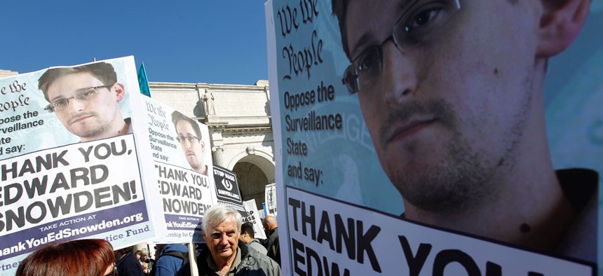 Demonstrators holds up banners with the photo of Edward Snowden during a protest outside in Washington in October.