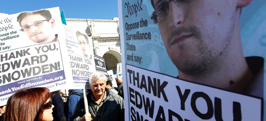 Demonstrators holds up banners with the photo of Edward Snowden during a protest outside of the U.S. Capitol in Washington.
