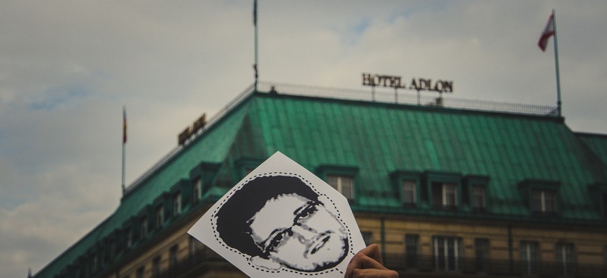A protestor holds up an Edward Snowden mask in Berlin.