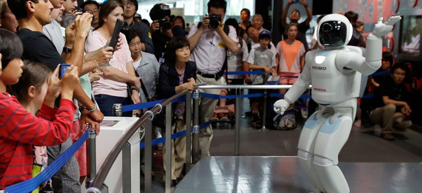 Honda Motor Co.’s interactive robot Asimo gestures while talking with visitors at a demonstration.