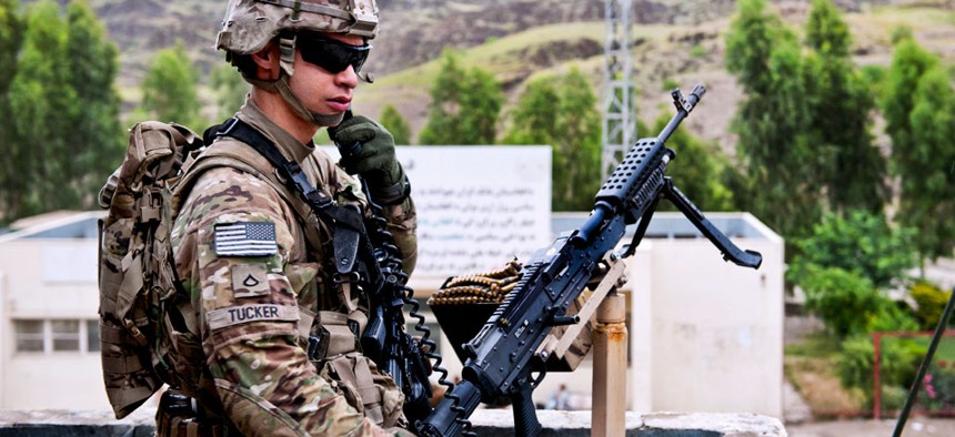 U.S. Army Pfc. Robert Tucker talks on his radio while providing rooftop security for the customs checkpoint at Torkham Gate in Afghanistan's Nangarhar province, April 24, 2013.