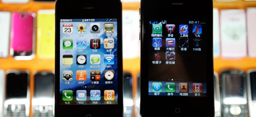 Two different fake iPhones are shown at a mobile phone market