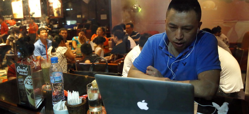 A Vietnamese man uses a laptop to go online by a 3G device inserted into a USB pot at a cafe in Ha Noi, Viet Nam.