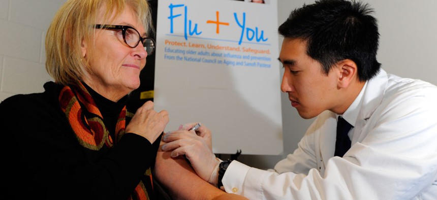harmacist Jason To gives a flu shot to Diane Marie Dash.